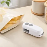 Mini selladora blanca junto a una bolsa de aperitivo abierta sobre la encimera de la cocina