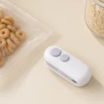 Mini selladora blanca junto a una bolsa transparente de cereales y un bol de avena