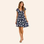 Donna con abito estivo blu navy con fiori bianchi, maniche corte ad aletta e gonna svasata