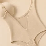 Primer plano de un body beige con espalda en V bajo, regulador del tirante y broches inferiores