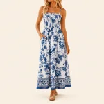 Donna con abito lungo bianco a fiori blu, spalline sottili e bordo decorato sull'orlo