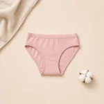 Slip bikini rosa stesi accanto a un asciugamano bianco e una capsula di cotone