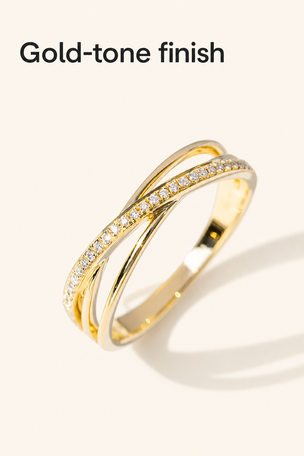 Detalle de una sola banda de piedras sobre la parte dorada pulida del anillo, bajo el título Gold-tone finish.