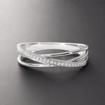 Vista frontale di un anello color argento su grigio scuro, con una fascia di pietre che incrocia una curva lucida.