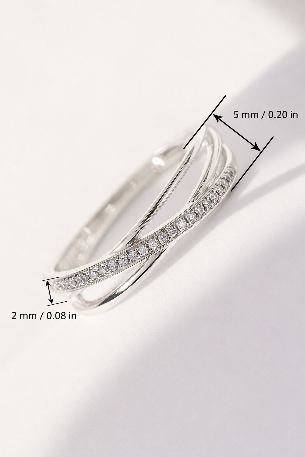 Un anillo plateado de líneas cruzadas con las medidas 5 mm / 0,20 pulgadas y 2 mm / 0,08 pulgadas junto a las zonas señaladas.