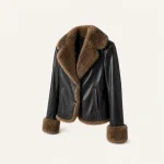 Frontansicht einer schwarzen Jacke mit breitem braunem Flauschkragen, passenden Bündchen, Besatz und vertikalen Taschen