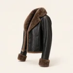 Schrägansicht einer schwarzen Knopfjacke mit braunem Flauschkragen, Bündchen und Saumbesatz