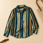 Striped button-front shirt laid flat beside a belt and the edge of a tote bag