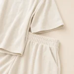 Close-up of the off-white set showing vertical ribs, the top hem and gathered shorts waistband