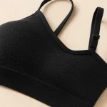 Close-up of a black bralette showing ribbed fabric, a strap adjuster and the lower band
