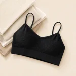 Black ribbed bralette laid flat beside folded light-colored fabric