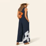 Rückansicht eines marineblauen Jumpsuits mit weitem Bein und einer orangefarbenen Blume am oberen Rücken