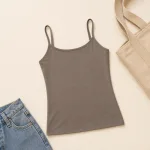 Taupe thin-strap camisole laid flat beside blue jeans and a canvas bag