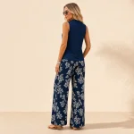 Vista posteriore di una donna con top blu navy semplice senza maniche e pantaloni palazzo floreali