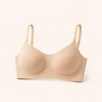Front view of a beige bra with smooth shaped cups and adjustable shoulder straps