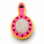 Close-up of a pink mirror charm with yellow edging and textured center
