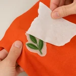 Excess backing lifted from the reverse of a small leaf embroidery