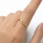 One gold-color open ring worn alone on an adult finger