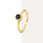 Anillo dorado en posición vertical con lente oscura y aro abierto