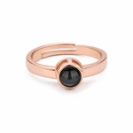 Vista frontal de un anillo de color oro rosa con extremos abiertos detrás de la lente