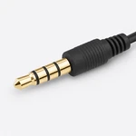 Primer plano del conector dorado de cuatro contactos, tres anillos negros y protección estriada del cable