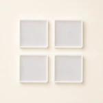 Four milky translucent square coaster molds arranged in a two-by-two layout