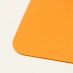 Close-up of the smooth surface and rounded corner of an orange silicone mat