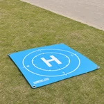 Blue landing pad laid on grass outdoors