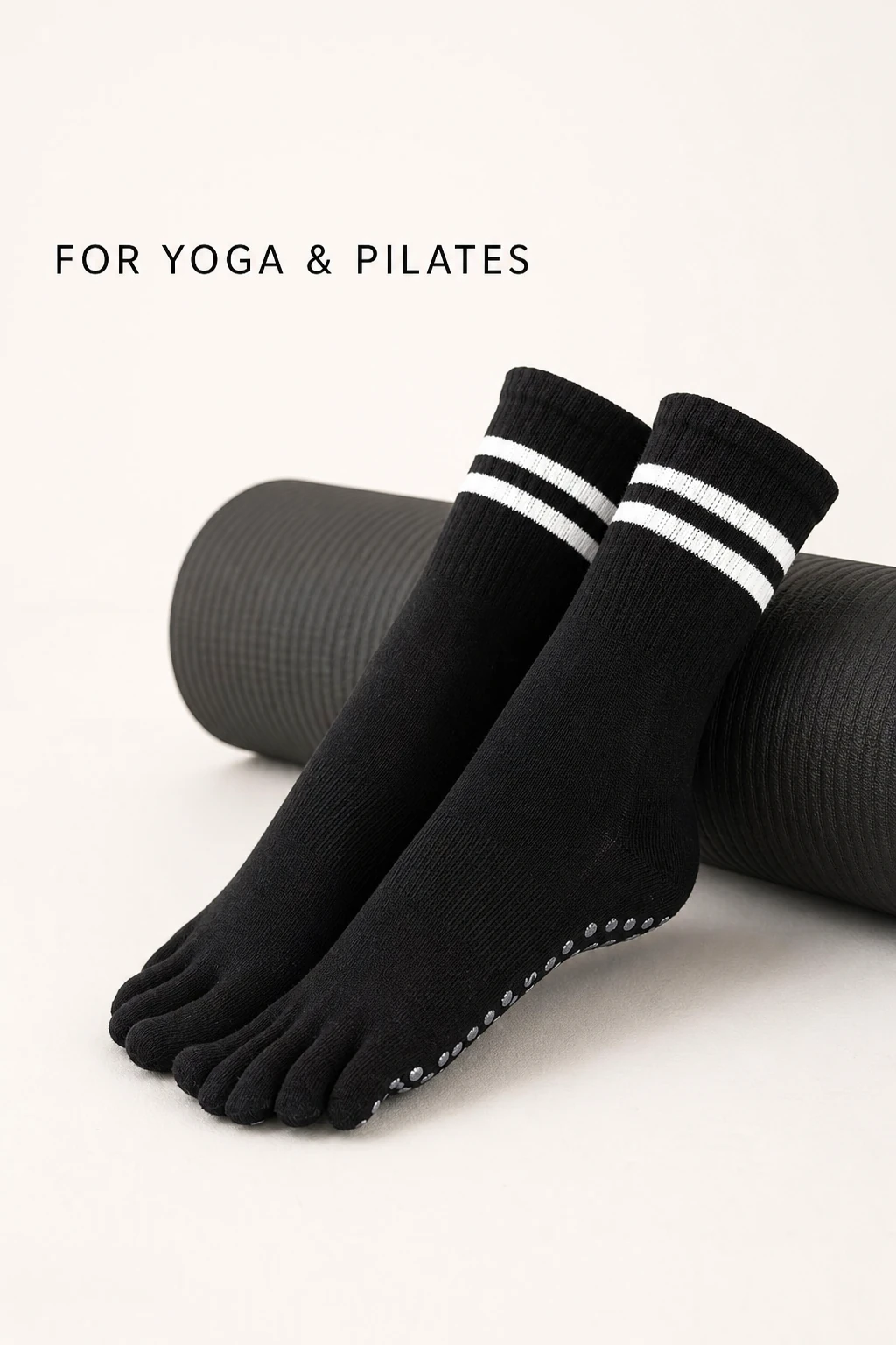 Black five-toe socks beside an exercise mat