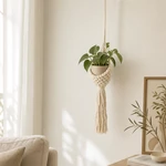 Beige plant hanger styled with a green plant and pot in a neutral living room.