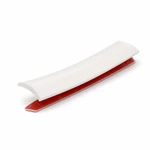 One white PVC trim sample with its red adhesive release liner visible underneath.