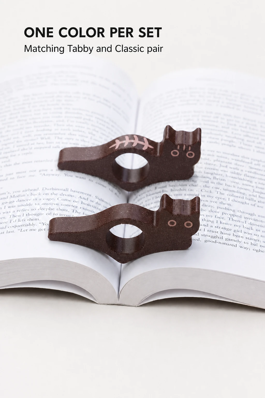 Dark-brown pair resting over an open book.