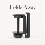 Black desk-clamp headphone holder folded upright beside its clamp, with “Folds Away” headline.