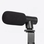 Gros plan sur le microphone noir avec bonnette en mousse, support incliné et molette de réglage nervurée