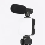 Gros plan sur un panneau lumineux rectangulaire blanc monté sous un microphone noir avec bonnette en mousse