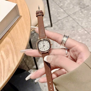 Brown-strap watch held open in a hand, full original color photograph