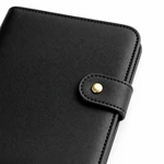 Close-up of the black organizer showing its fine surface texture, stitching and gold-tone snap