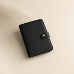 Black watch strap organizer closed and placed at an angle on a light surface