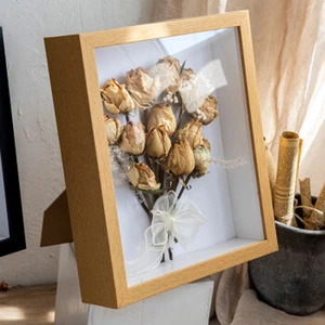 Option photo: light-brown wooden frame styled with dried flowers; flowers not included
