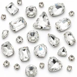 Close-up of clear glass sew-on rhinestones in varied visible shapes, each held by a claw setting.