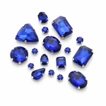 A cluster of royal-blue glass sew-on rhinestones in varied visible shapes on white.