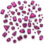 A cluster of rose-red glass sew-on rhinestones in varied visible shapes on white.