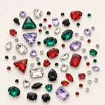 Representative spread of mixed-color glass sew-on rhinestones with visible claw settings on warm white.