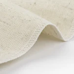 Close-up of the couche’s woven linen texture and overlocked edge
